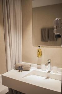 La salle de bains est pourvue d'un lavabo blanc et d'un miroir. dans l'établissement La Valiz, à Lille