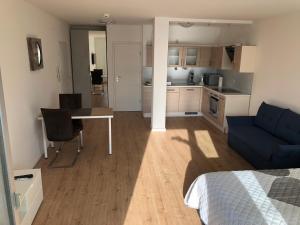 a room with a bed and a desk and a kitchen at Apartment Augsburg Mitte in Augsburg