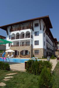 a large building with a swimming pool in front of it at Top Complex in Sveti Vlas