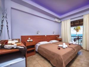 a hotel room with two beds and a balcony at Onar Corfu Aparts & Studios in Ipsos