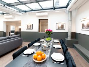 una sala da pranzo con tavolo e arance di LivinParis - Luxury AC 3 Bedrooms Le Marais I a Parigi
