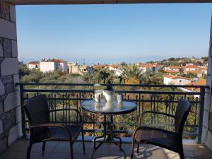 a table and chairs on a balcony with a view at Villa Orestis in Stoupa
