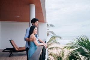 un hombre y una mujer de pie en un balcón en Saint Tropez Beach Hotel, en Chao Lao Beach