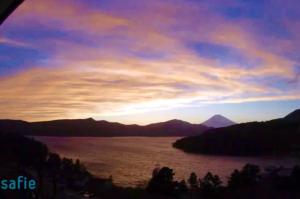 una puesta de sol sobre un gran cuerpo de agua en Chalet Itomic L, en Hakone