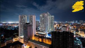 a city skyline at night with tall buildings at KL Tower Makati Apartments by PH Staycation in Manila