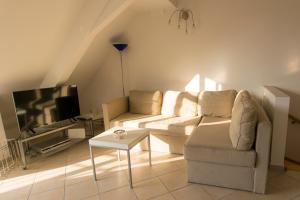 a living room with a couch and a tv at Kehrwieder in Warnemünde