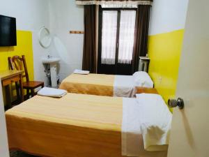 a hotel room with two beds and a sink at Hostal Ruano in Madrid