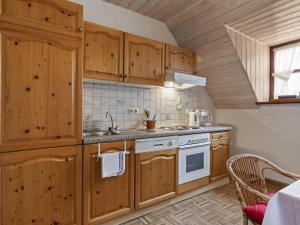 a kitchen with wooden cabinets and a stove at Secluded Apartment in Sch nsee Nearby the Forest in Schönsee