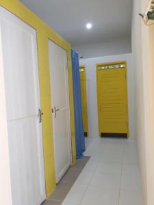 a hallway with two doors and a yellow door at Nipah Villas in Senggigi 