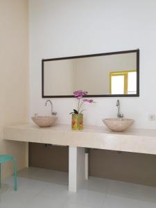 a bathroom counter with two sinks and a mirror at Nipah Villas in Senggigi 