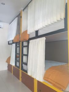 a bedroom with a bunk bed with white curtains at Nipah Villas in Senggigi 