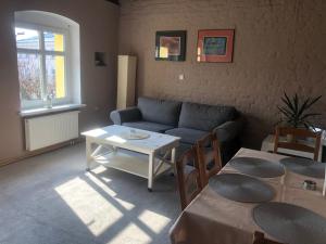 salon z kanapą i stołem w obiekcie Apartament przy Rynku 2 w mieście Połczyn-Zdrój