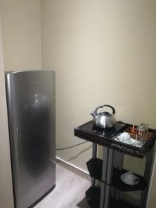 a kitchen with a refrigerator and a tea kettle on a table at Max B&B in East London
