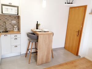 a small kitchen with a table with a chair and a door at Apartments Palma in Baška Voda