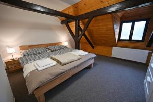 1 dormitorio con 1 cama grande en una habitación con paredes de madera en Chalupa pod Libínem, en Zbytiny