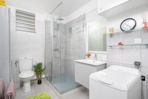ein Bad mit einem WC, einem Waschbecken und einer Dusche in der Unterkunft Navira Appartement Bleu Nuit in Quartier Châteauboeuf