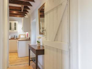 una puerta corredera de granero en una cocina con mesa en Sweetpea Cottage en Wiston