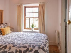 Schlafzimmer mit einem Bett und einem Fenster in der Unterkunft Sweetpea Cottage in Wiston