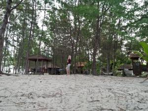 een vrouw op een strand met een frisbee bij Setia Homestay in Karimunjawa