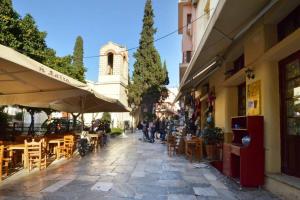 een straat met tafels en stoelen en een gebouw bij Plaka, Apartment in the old historical neighborhood of Athens in Athene