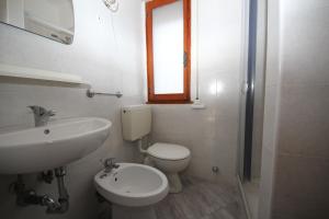 a bathroom with a sink and a toilet and a window at Villa Debby appartamento 01 in Rosolina Mare