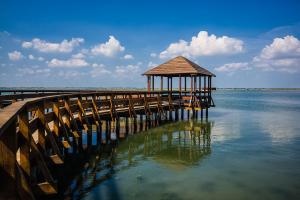 a wooden pier with a gazebo on the water at Villa Debby appartamento 01 in Rosolina Mare