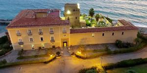an aerial view of a large yellow building with a tower at Villa la Ficuzza in Cittadella del Capo