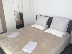 a large bed with two white towels on it at Private apartment near Brussels in Asse