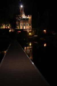 a lit up building with a reflection in the water at night at Apartments Castle on Uvildy Lake in Uvildy