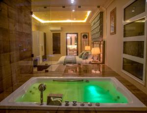 a bathroom with a green bath tub in a room at Home Suites Boutique Hotel in Freetown