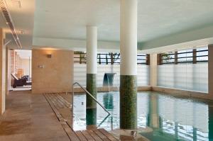 a swimming pool with columns in a building at Eurostars Palacio Buenavista in Toledo