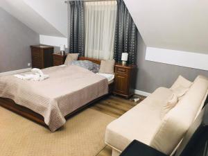 a bedroom with a bed and a couch at Hostel LaGoya z Restauracją in Nielisz