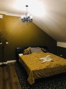 um quarto com uma cama e um lustre em Hostel LaGoya z Restauracją em Nielisz