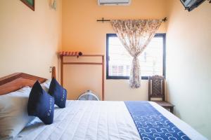 een slaapkamer met een bed met blauwe kussens en een raam bij Capital O Hotel Aurora, Tuxtla Gutiérrez in Tuxtla Gutiérrez
