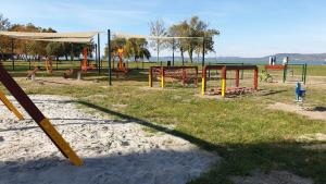 un parc avec une aire de jeux et une balançoire dans l'établissement Lelle Resort B26, à Balatonlelle