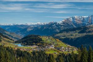 a town on a hill with mountains in the background at Pradas Resort Brigels in Breil/Brigels