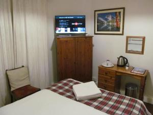 a bedroom with a bed and a television at Lantern Guest House in Edinburgh
