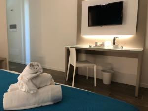 a hotel room with a desk and a pile of towels at B&B Alma Garda Lake in Peschiera del Garda