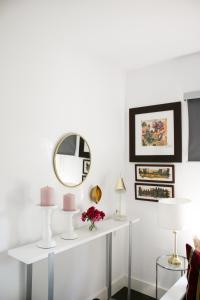 a living room with a white table with a mirror at Suite Garden House in Santa Cristina d'Aro