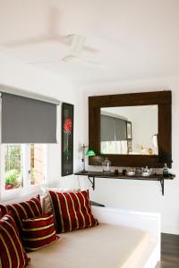 sala de estar con sofá y espejo en Suite Garden House, en Santa Cristina d'Aro