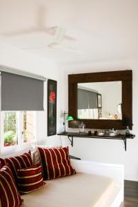 a living room with a couch and a mirror at Suite Garden House in Santa Cristina d'Aro