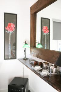 um espelho sobre um balcão com rosas em Suite Garden House em Santa Cristina d'Aro