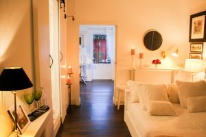 a living room with a white couch and a hallway at Suite Garden House in Santa Cristina d'Aro