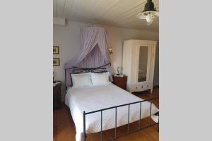 a bedroom with a white bed with a canopy at Chariklia Traditional House in Alonnisos Old Town