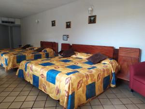 dwa łóżka siedzące obok siebie w pokoju w obiekcie Hotel Cabildos w mieście Tapachula