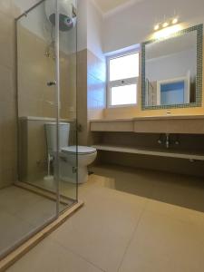 a bathroom with a toilet and a glass shower at Exotic Retreat 2 BR Apartment in Water Side Lagoon Pool in Hurghada