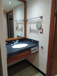 La salle de bains est pourvue d'un lavabo et d'un miroir. dans l'établissement Hotel Cabildos, à Tapachula