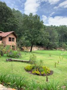 a yard with a house and a field of grass at CORTIJO LA CASONA & Bungalow al Pie de la Montaña in San Cristóbal de Las Casas