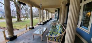 eine Veranda mit Stühlen und einem Tisch auf einem Haus in der Unterkunft Saravilla Bed & Breakfast in Alma
