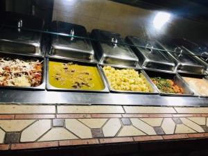 um buffet cheio de diferentes tipos de alimentos em bandejas em HOTEL JERICO em Zamora de Hidalgo